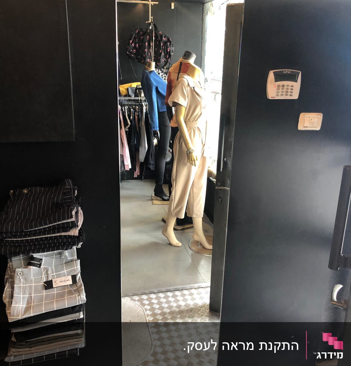 בובת תצוגה משתקפת במראה זכוכית בחנות בגדים